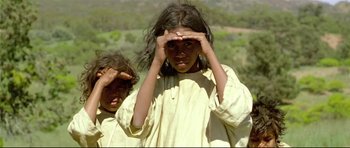 Movie still from “Rabbit-Proof Fence” (2002), directed by Phillip Noyce – A young girl covering her eyes while standing next to a young boy; Close Up shot, Low angle