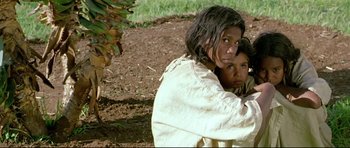 Movie still from “Rabbit-Proof Fence” (2002), directed by Phillip Noyce – A woman and a child are standing in the dirt; Medium shot, Low angle