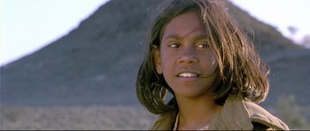 Movie still from “Rabbit-Proof Fence” (2002), directed by Phillip Noyce – A young girl is smiling for the camera; Close Up shot, High angle