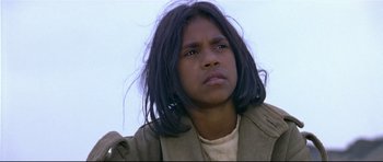 Movie still from “Rabbit-Proof Fence” (2002), directed by Phillip Noyce – A person with long black hair is looking at the camera; Close Up shot, High angle