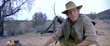 Movie still from “Rabbit-Proof Fence” (2002), directed by Phillip Noyce – A man wearing a hat and holding a rifle; Medium shot, Low angle