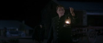 Movie still from “Rabbit-Proof Fence” (2002), directed by Phillip Noyce – A man holding a lantern while standing next to another man; Medium shot, Low angle