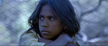 Movie still from “Rabbit-Proof Fence” (2002), directed by Phillip Noyce – A young man with long black hair is looking at the camera; Close Up shot, High angle