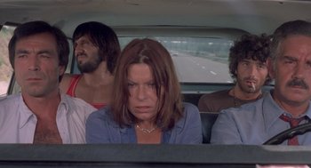 Movie still from “Rabid Dogs” (1974), directed by Mario Bava – A group of people sitting in the back of a car; Medium shot, High angle
