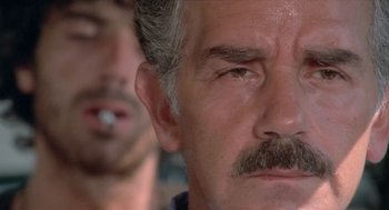 Movie still from “Rabid Dogs” (1974), directed by Mario Bava – An older man with a mustache; Close Up shot, Low angle