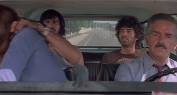 Movie still from “Rabid Dogs” (1974), directed by Mario Bava – Two men sitting in the back seat of a car; Medium shot, Low angle