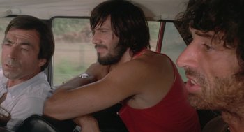 Movie still from “Rabid Dogs” (1974), directed by Mario Bava – A man sitting in the passenger seat of a car; Close Up shot, Low angle