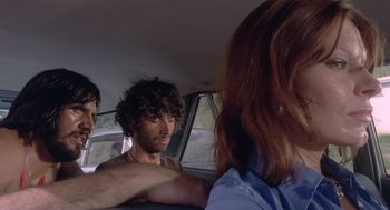 Movie still from “Rabid Dogs” (1974), directed by Mario Bava – Three people sitting in the back seat of a car; Close Up shot, Low angle