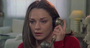 Movie still from “Rabid Dogs” (1974), directed by Mario Bava – A woman holding a phone up to her ear; Close Up shot, High angle