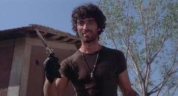 Movie still from “Rabid Dogs” (1974), directed by Mario Bava – A man holding a sword in his right hand; Close Up shot, Low angle