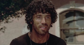 Movie still from “Rabid Dogs” (1974), directed by Mario Bava – A person wearing a black shirt; Close Up shot, Low angle