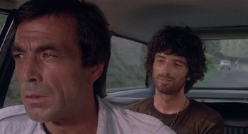 Movie still from “Rabid Dogs” (1974), directed by Mario Bava – Two men sitting in the back seat of a car; Close Up shot, Low angle