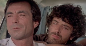 Movie still from “Rabid Dogs” (1974), directed by Mario Bava – Two men sitting next to each other in a car; Close Up shot, Low angle