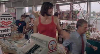 Movie still from “Rabid Dogs” (1974), directed by Mario Bava – A man standing in front of a cash register; Medium shot, Over the shoulder angle