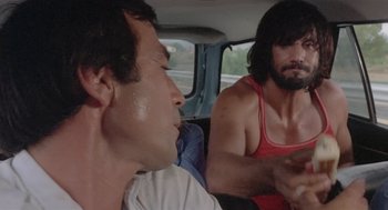 Movie still from “Rabid Dogs” (1974), directed by Mario Bava – Two men sitting in the back of a car; Close Up shot, Over the shoulder angle