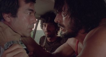 Movie still from “Rabid Dogs” (1974), directed by Mario Bava – A group of men standing next to each other in a car; Close Up shot, Low angle
