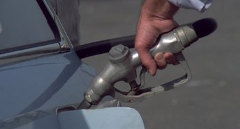 Movie still from “Rabid Dogs” (1974), directed by Mario Bava – A person is pumping gas into a vehicle; Extreme Close Up shot, High angle