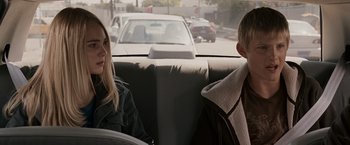 Movie still from “Race to Witch Mountain” (2009), directed by Andy Fickman – Two people sitting in the back seat of a car; Close Up shot, Over the shoulder angle
