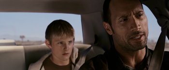 Movie still from “Race to Witch Mountain” (2009), directed by Andy Fickman – A man and a boy sitting in a car; Close Up shot, Over the shoulder angle