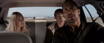 Movie still from “Race to Witch Mountain” (2009), directed by Andy Fickman – A man and a boy sitting in the back of a car; Close Up shot, Over the shoulder angle