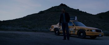 Movie still from “Race to Witch Mountain” (2009), directed by Andy Fickman – A man standing in front of a yellow truck; Wide shot, Over the shoulder angle
