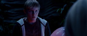 Movie still from “Race to Witch Mountain” (2009), directed by Andy Fickman – A young boy is looking at the camera in the dark; Close Up shot, Over the shoulder angle
