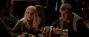 Movie still from “Race to Witch Mountain” (2009), directed by Andy Fickman – Two people sitting at a table in front of a bottle; Close Up shot, Over the shoulder angle