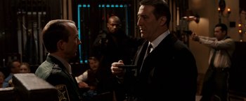 Movie still from “Race to Witch Mountain” (2009), directed by Andy Fickman – A man in a suit and tie holding a pen; Medium shot, Over the shoulder angle