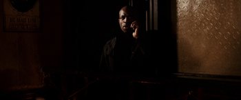 Movie still from “Race to Witch Mountain” (2009), directed by Andy Fickman – A man in a dark room talking on a cell phone; Medium shot, Low angle