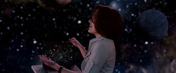 Movie still from “Race to Witch Mountain” (2009), directed by Andy Fickman – A woman holding a computer in front of a star filled sky; Medium shot, Over the shoulder angle