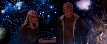 Movie still from “Race to Witch Mountain” (2009), directed by Andy Fickman – A boy and a girl standing next to each other in front of a space background; Medium shot, Low angle