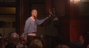 Movie still from “Rachel Getting Married” (2008), directed by Jonathan Demme – A man standing next to another man on a stage; Medium shot, Over the shoulder angle