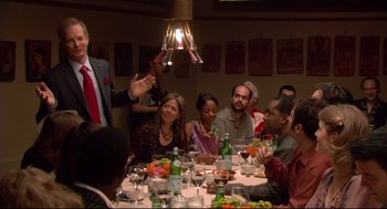 Movie still from “Rachel Getting Married” (2008), directed by Jonathan Demme – A group of people sitting at a table with food; Medium shot, Over the shoulder angle