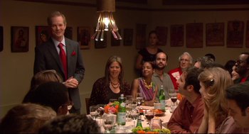 Movie still from “Rachel Getting Married” (2008), directed by Jonathan Demme – A group of people sitting around a table with food on top of it; Medium shot, Over the shoulder angle