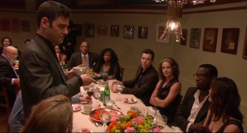 Movie still from “Rachel Getting Married” (2008), directed by Jonathan Demme – A group of people sitting at a table with food; Medium shot, High angle