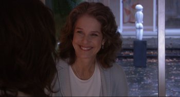Movie still from “Rachel Getting Married” (2008), directed by Jonathan Demme – A woman with long brown curly hair smiling for the camera; Close Up shot, Over the shoulder angle