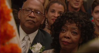 Movie still from “Rachel Getting Married” (2008), directed by Jonathan Demme – A man and a woman in formal wear posing for a picture; Close Up shot, High angle