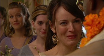 Movie still from “Rachel Getting Married” (2008), directed by Jonathan Demme – A woman with long dark brown hair wearing a dress and earrings; Close Up shot, Over the shoulder angle