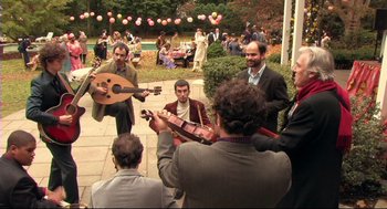 Movie still from “Rachel Getting Married” (2008), directed by Jonathan Demme – A group of people gathered around playing music; Wide shot, High angle