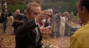 Movie still from “Rachel Getting Married” (2008), directed by Jonathan Demme – A man holding a wine glass in his right hand; Medium shot, Over the shoulder angle