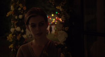 Movie still from “Rachel Getting Married” (2008), directed by Jonathan Demme – A woman standing next to a tree with lights in the background; Close Up shot, Over the shoulder angle