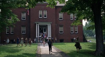 Movie still from “Rachel, Rachel” (1968), directed by Paul Newman – A group of people gathered in front of a brick building; Extreme Wide shot, High angle