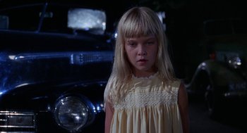 Movie still from “Rachel, Rachel” (1968), directed by Paul Newman – A girl in a yellow dress standing in front of an old car; Close Up shot, High angle