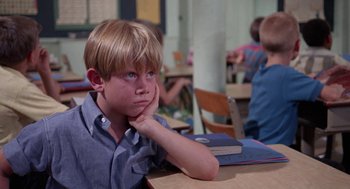 Movie still from “Rachel, Rachel” (1968), directed by Paul Newman – A boy sitting at a table with his hand under his chin; Close Up shot, High angle
