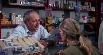 Movie still from “Rachel, Rachel” (1968), directed by Paul Newman – A man and a woman sitting at a table in a store; Medium shot, Over the shoulder angle