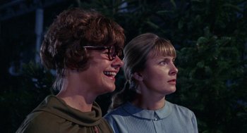 Movie still from “Rachel, Rachel” (1968), directed by Paul Newman – Two women standing next to each other in front of trees; Close Up shot, Low angle