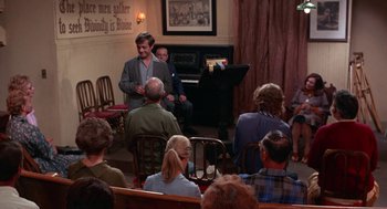 Movie still from “Rachel, Rachel” (1968), directed by Paul Newman – A group of people sitting in front of a piano; Wide shot, High angle