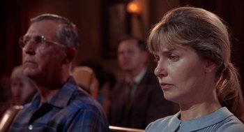 Movie still from “Rachel, Rachel” (1968), directed by Paul Newman – A man and a woman are sitting in front of other people; Close Up shot, Low angle
