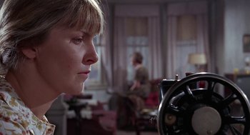 Movie still from “Rachel, Rachel” (1968), directed by Paul Newman – A woman looking into a sewing machine in a living room; Close Up shot, Low angle
