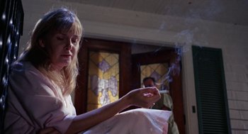 Movie still from “Rachel, Rachel” (1968), directed by Paul Newman – A woman smoking a cigarette in front of a stained glass window; Medium shot, Low angle